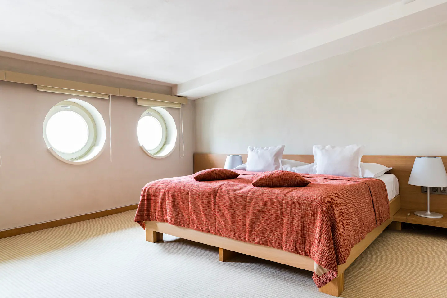 Tulip Residence bedroom with twin porthole windows and red textured throw