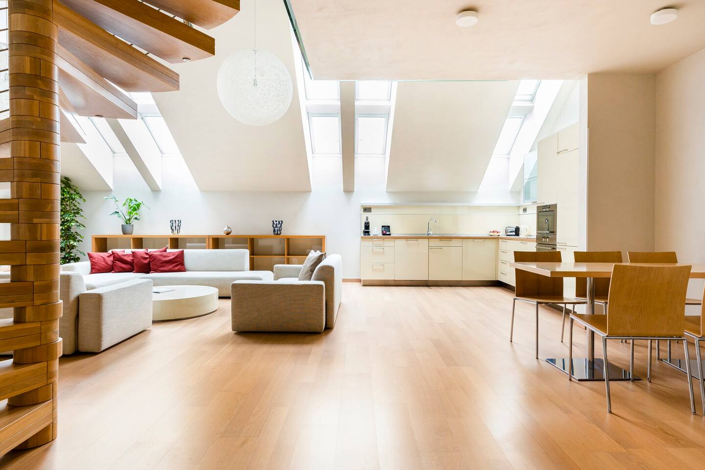 Open-plan living, dining and kitchen in a Roset residence beneath skylights